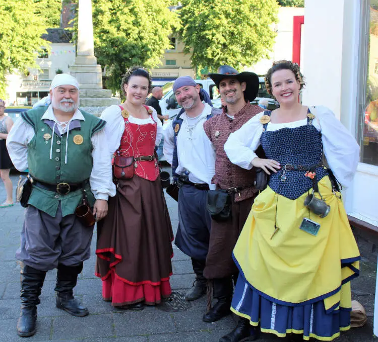 Bounding Main poses for a photo. The group features three white men and two white women in mariner's clothing.